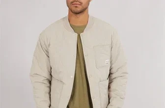 Modell trägt eine beige gesteppte Jacke von Jack & Jones mit Knöpfen und Brusttasche