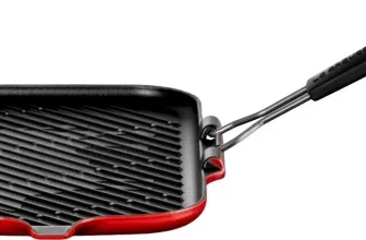 Rote Le Creuset Steakgrillpfanne mit schwarzem Griff und diagonaler Grillstruktur auf weißem Hintergrund