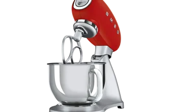Rote Smeg Küchenmaschine mit silbernem Rührschüssel-Becken und Drahtbesen auf schwarzem Hintergrund