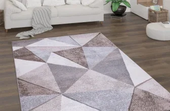 Teppich mit geometrischem Dreiecksmuster in Grau- und Brauntönen auf hellem Holzboden im Wohnzimmer