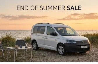 Weißer VW Caddy California am Strand mit Campingtisch bei Sonnenuntergang, Text: End of Summer Sale