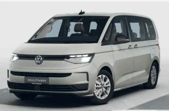 Vorderansicht eines hellgrauen Volkswagen Multivan mit aktiven LED-Scheinwerfern und VW-Logo auf der Front.