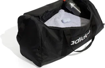 Schwarze Adidas Duffel Bag offen mit Handtuch, Flasche und Ohrhörern