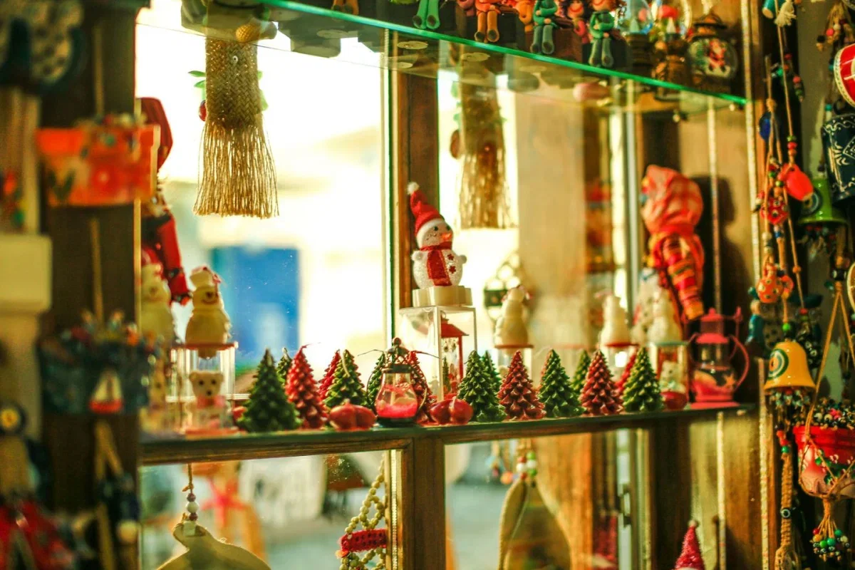 Weihnachtliche Dekoration mit kleinen Tannenbäumen und Schneemännern in einem Schaufenster zur Weihnachtsvorbereitung 2026