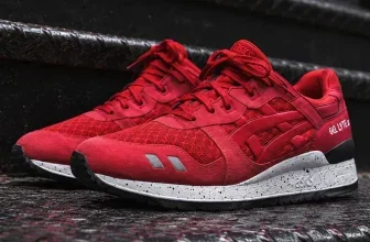 Rotes ASICS Gel-Lyte III Sneaker-Paar auf dunkler, rutschfester Metallstange