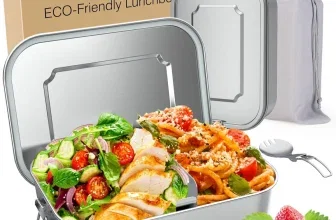Edelstahl-Lunchbox mit Salat und Nudeln, daneben Verpackung, Beutel und Löffel-Gabel