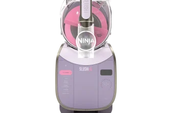 Lila Ninja SLUSHi XL Eismaschine mit transparentem Deckel und pinken Innenbestandteilen auf schwarzem Hintergrund.