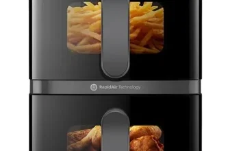 Schwarze Philips Heißluftfritteuse mit zwei Fächern, in denen Pommes und Hähnchen sichtbar sind.