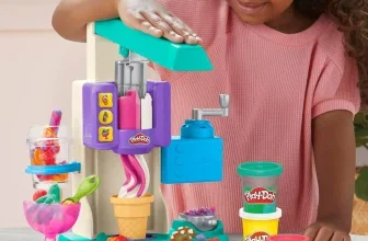 Mädchen bedient Play-Doh Eismaschine mit buntem Teig und Bechern