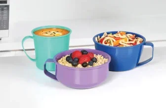 Drei bunte Sistema-Mikrowellenbecher mit Suppe, Nudeln und Müsli vor weißem Hintergrund