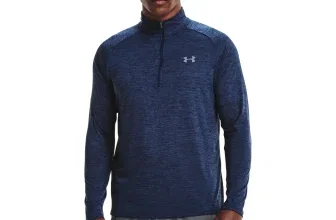 Mann in blauem Under Armour Langarmshirt mit halbem Reißverschluss und grauen Hosen