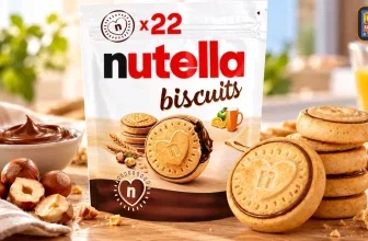 Nutella Biscuits Packung mit Keksen, Schüssel Nutella und Haselnüssen auf Holztisch